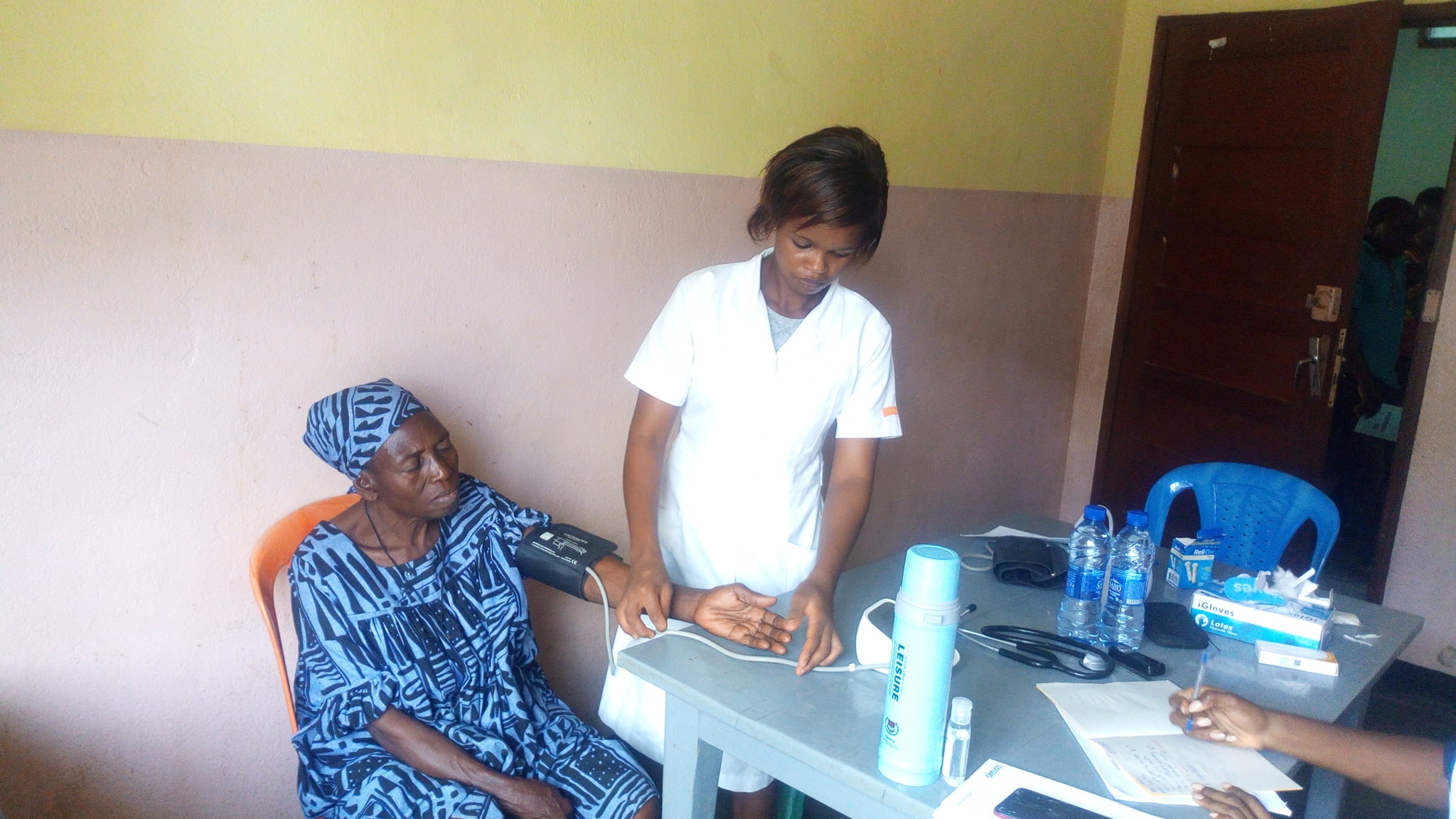 Photo d'une femme qui prend la tension d'une patiente durant une Journée Médicale de Makénéné